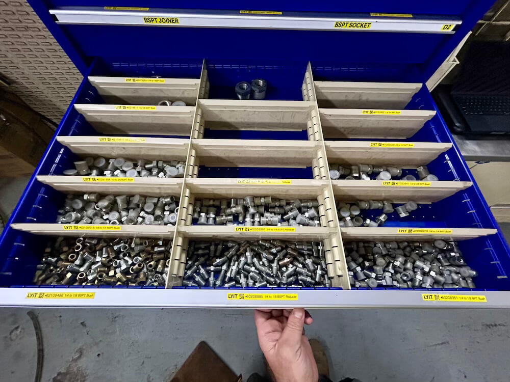 lyit-parts-drawer-with-barcodes Worker stocking parts shelves inside a site storage container