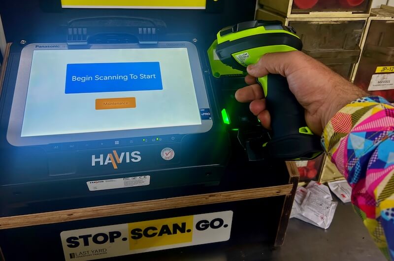 Close-up of LYIT terminal with worker holding handheld barcode scanner