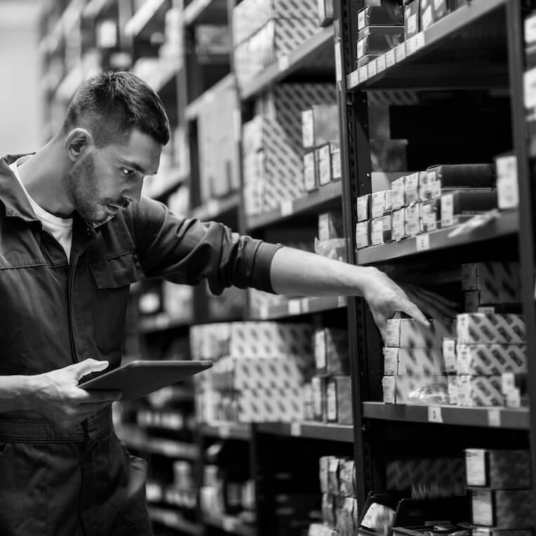 Worker stocking parts shelves inside a site storage container